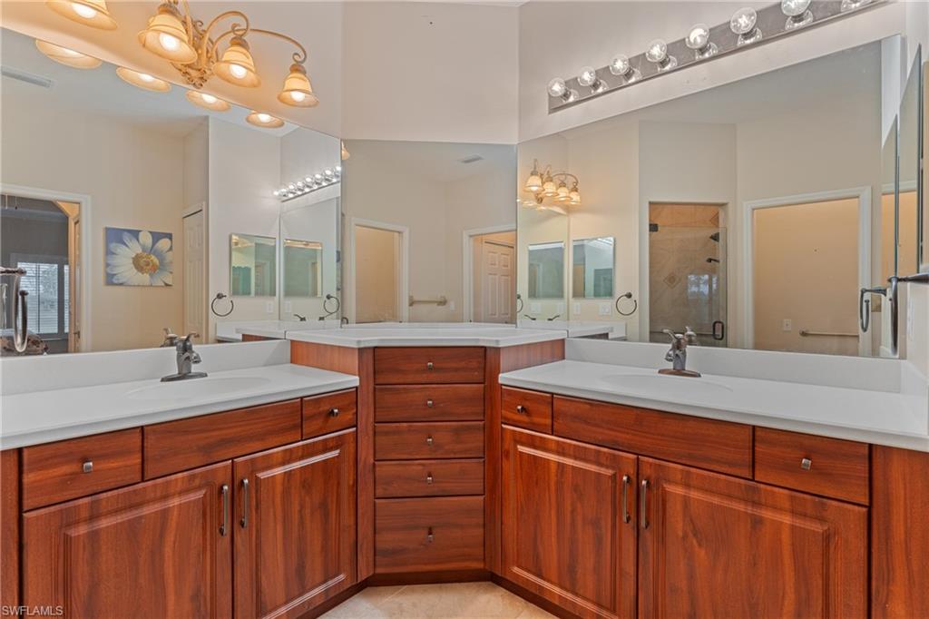 Bathroom featuring vanity, tile patterned floors, and a shower with door
