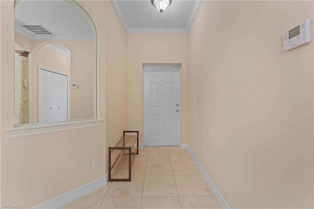 Hallway featuring light tile patterned floors and ornamental molding