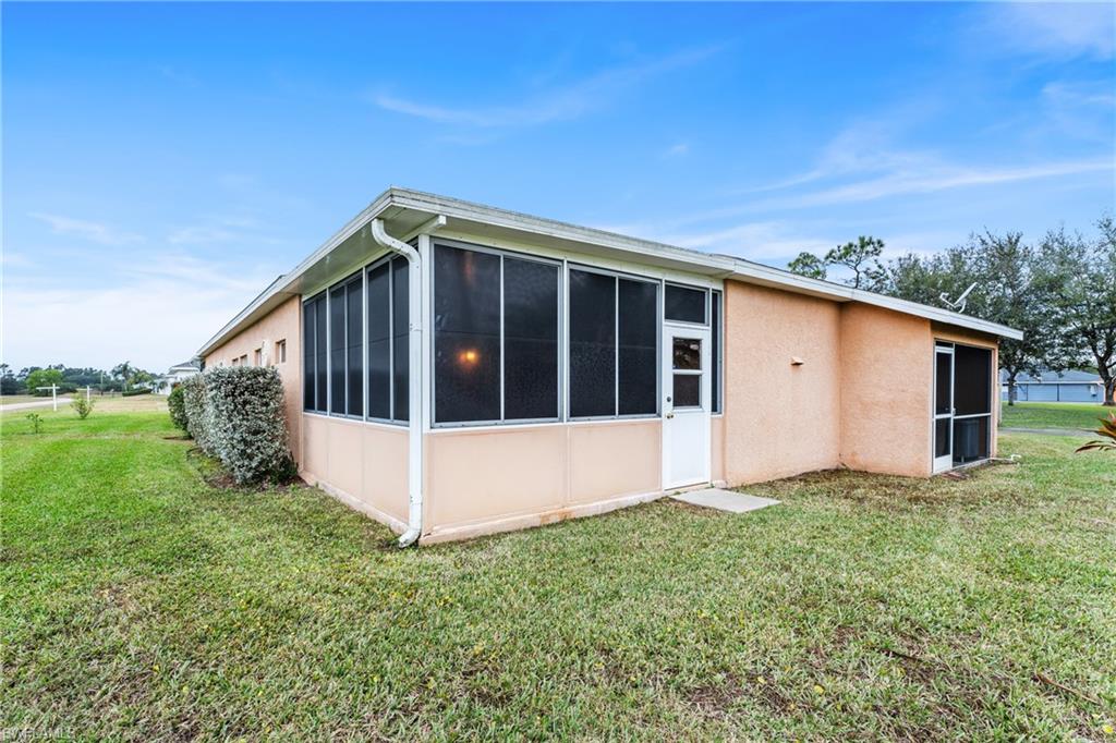 Back of house featuring a sunroom and a lawn