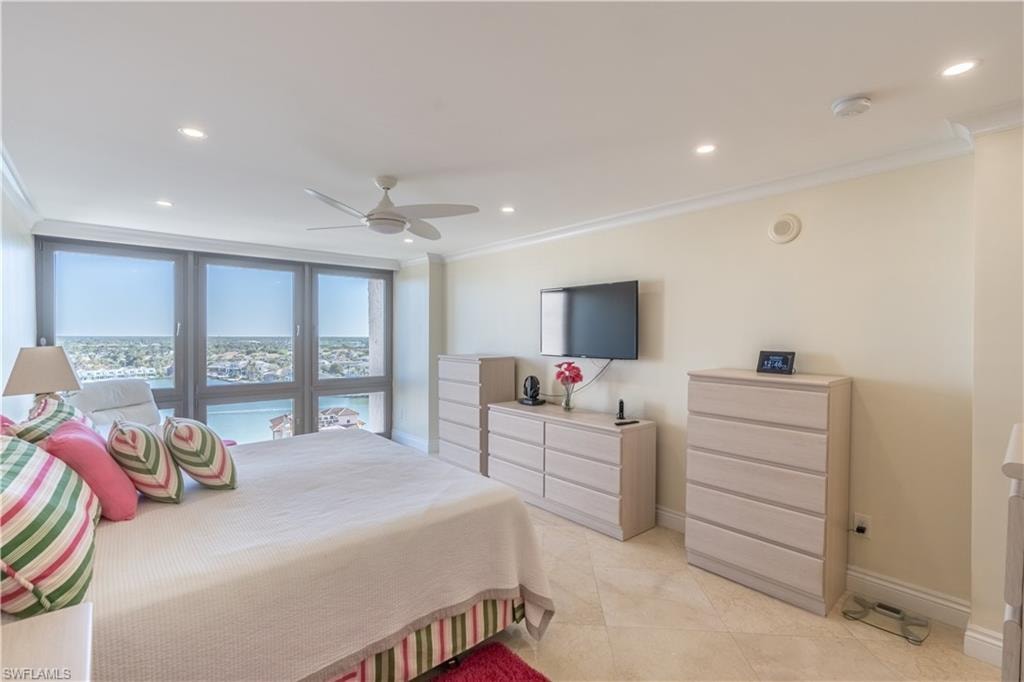 Primary bedroom with ceiling fan and ornamental molding
