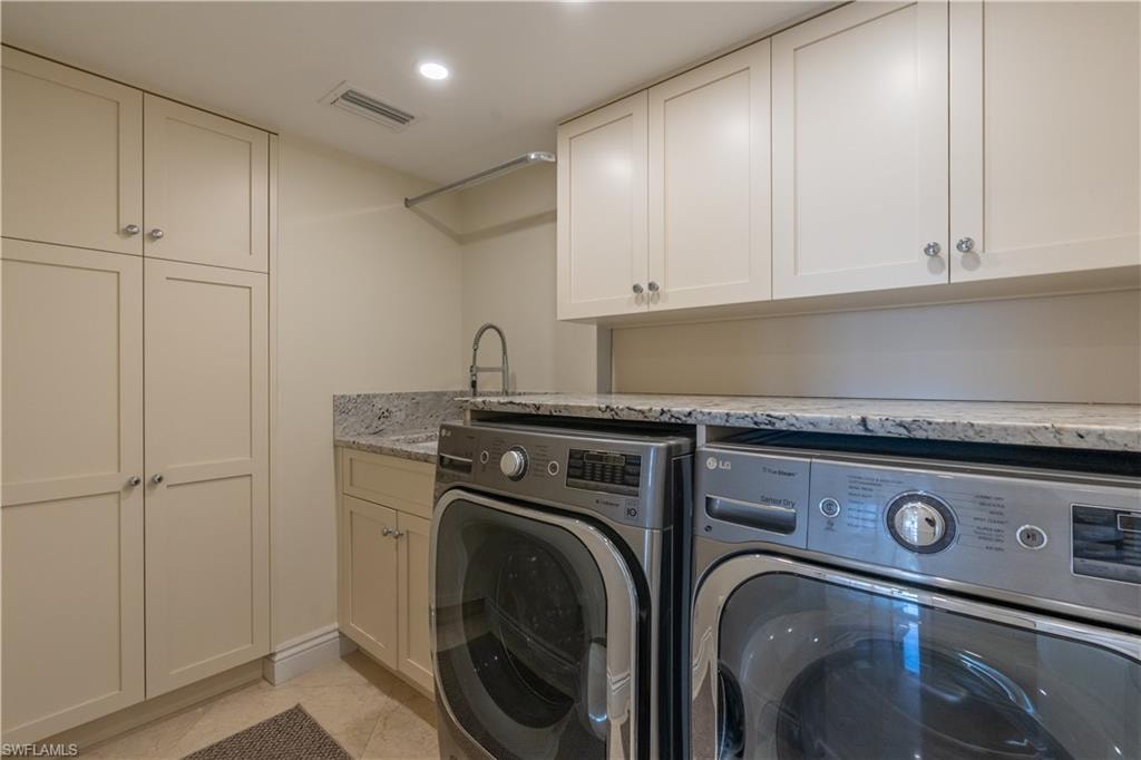 Laundry room featuring sink, cabinets, separate washer and dryer, and light tile patterned flooring