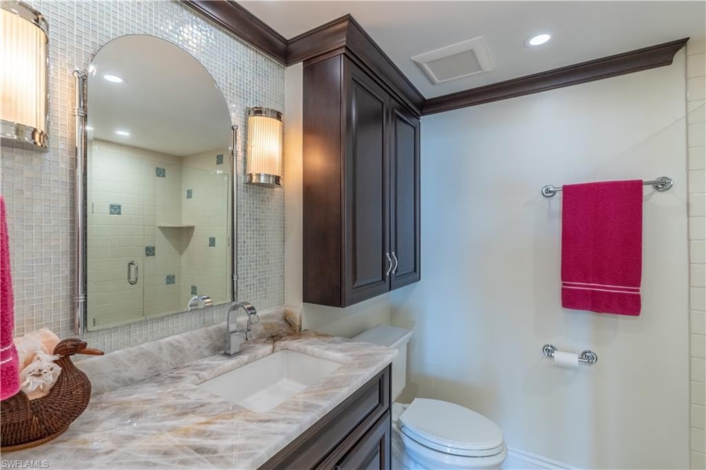 Third Bathroom featuring vanity, crown molding, a shower with door, and toilet