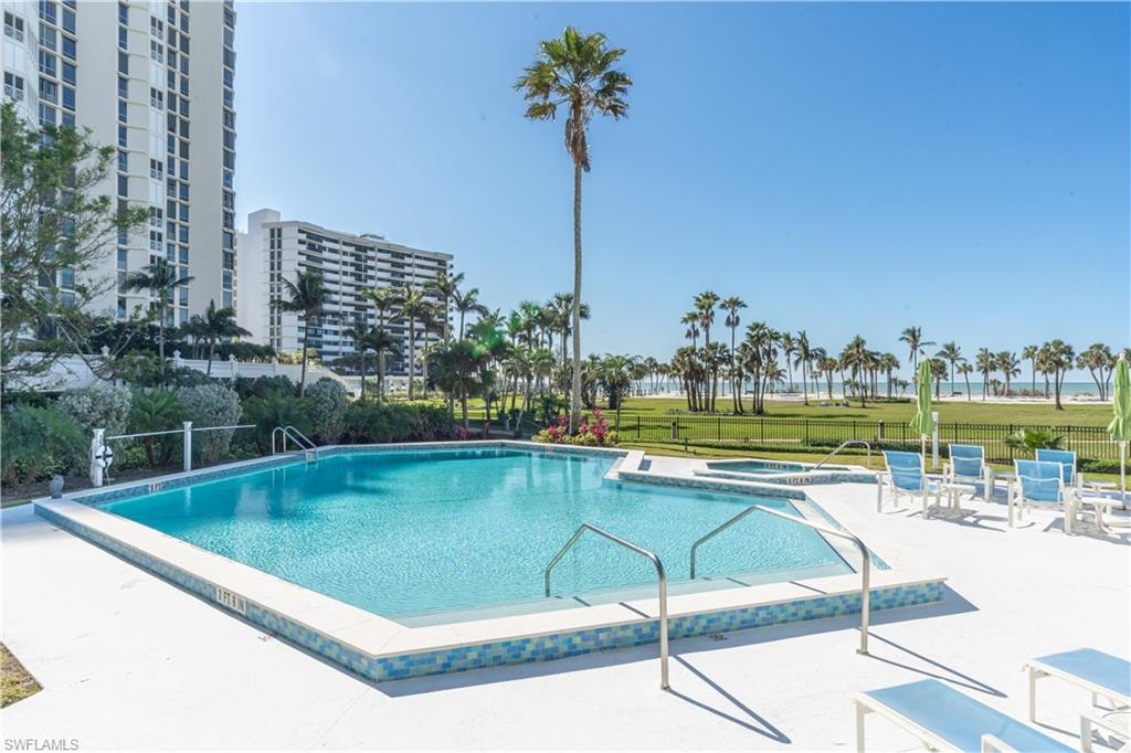 View of swimming pool featuring a hot tub and a patio