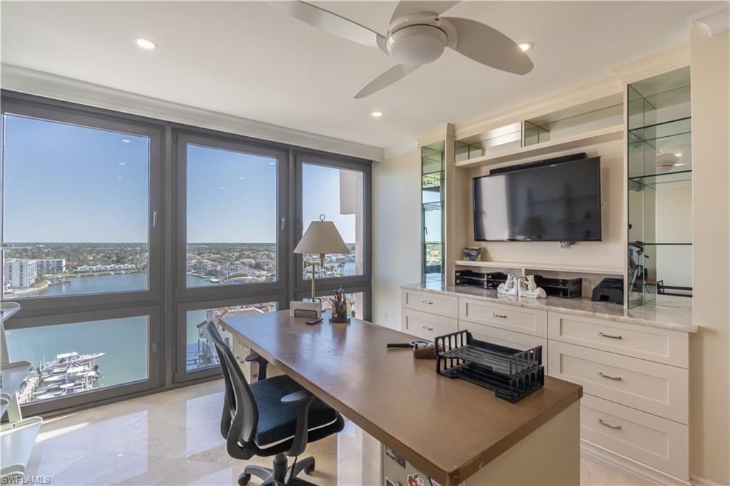 Office space featuring ornamental molding, a water view, and ceiling fan