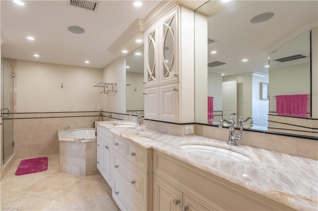 Primary Bathroom featuring shower with separate bathtub, tile patterned flooring, and vanity