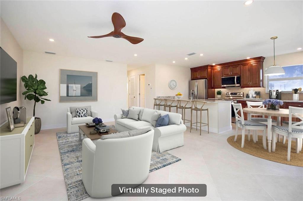 Living room featuring light tile patterned floors and ceiling fan