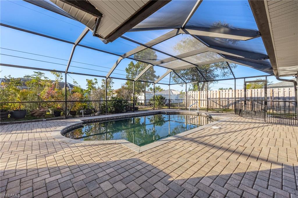 View of swimming pool with a patio area and glass enclosure
