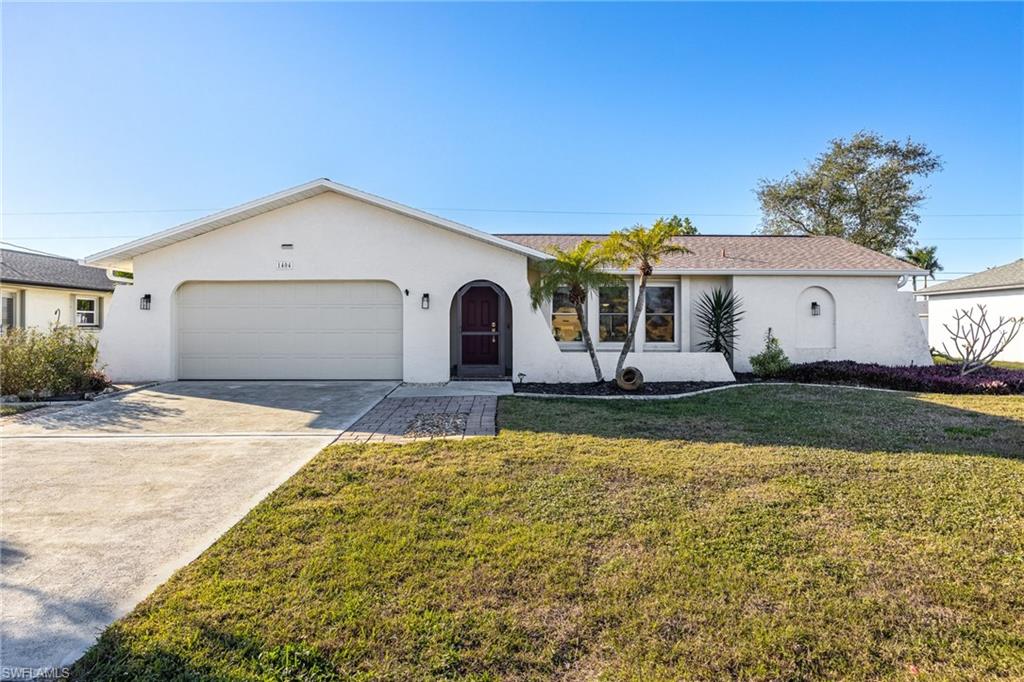 Ranch-style home featuring a garage and a front yard