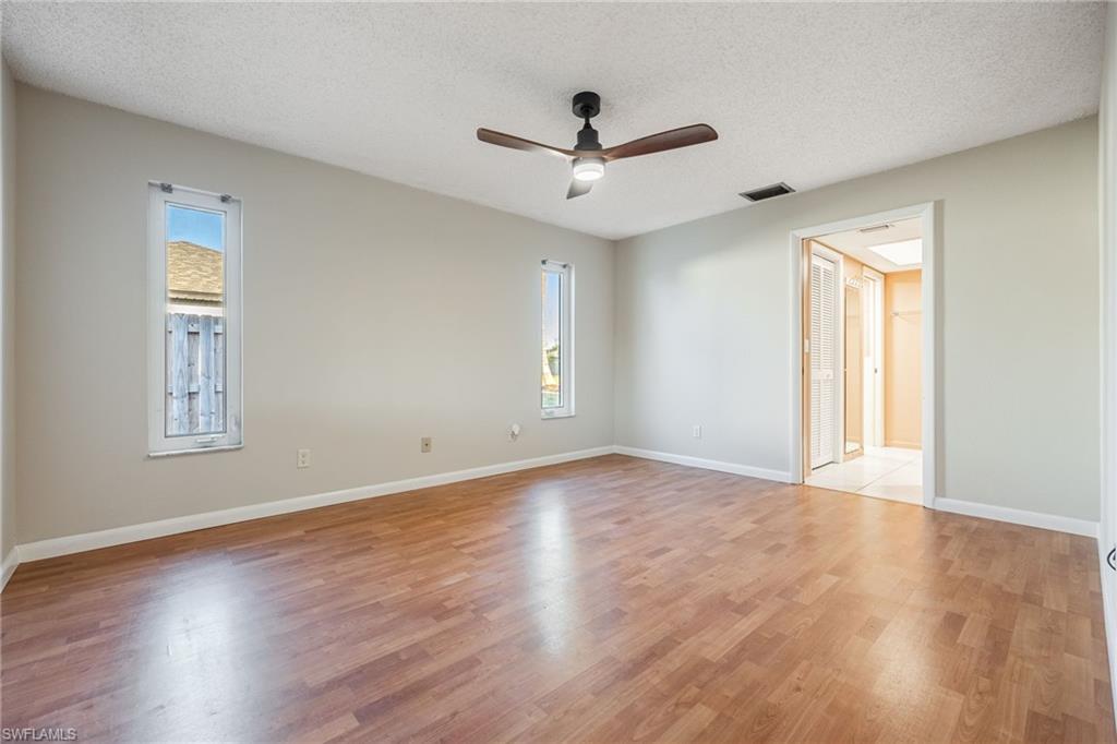 Unfurnished room featuring ceiling fan, a textured ceiling, and light wood-type flooring