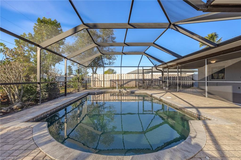 View of pool featuring a patio and glass enclosure