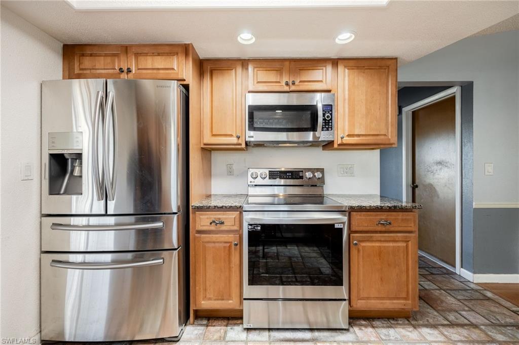 Kitchen with stainless steel appliances and stone counters