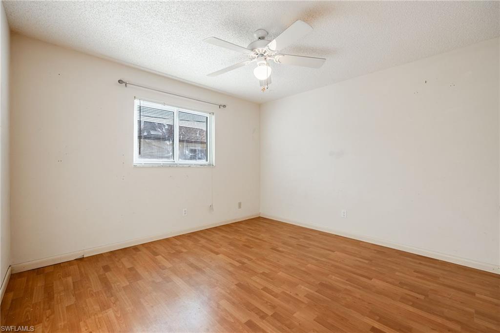 Unfurnished room featuring wood-type flooring, ceiling fan, and a textured ceiling