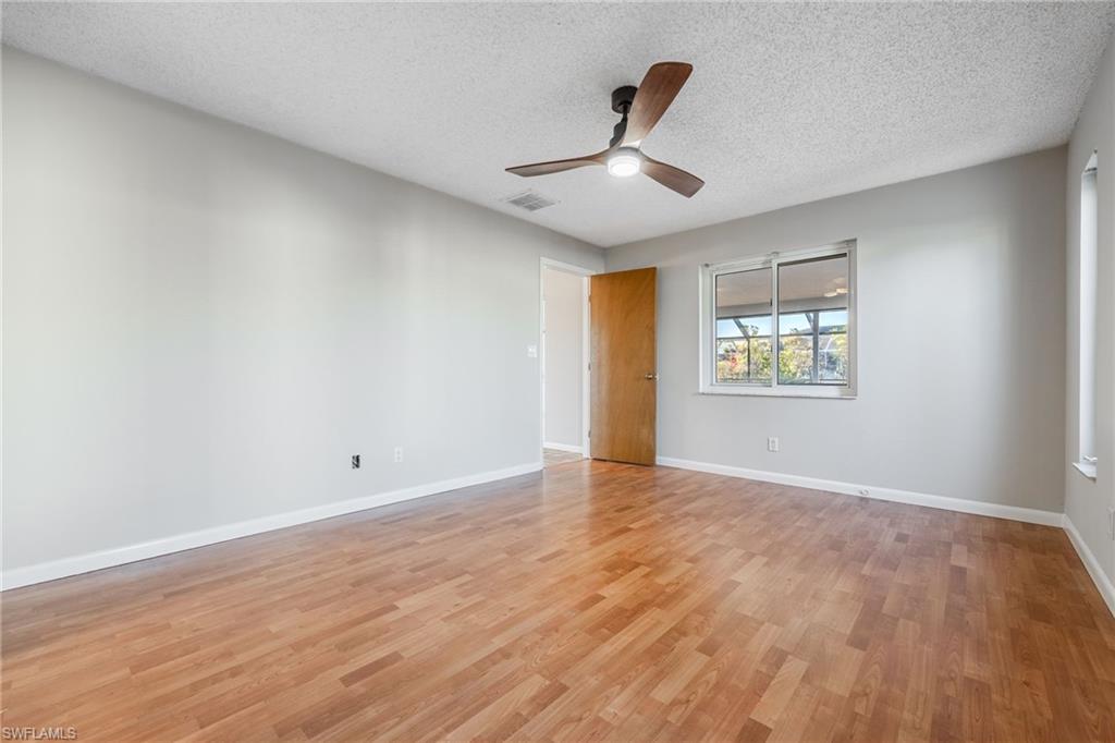 Empty room featuring ceiling fan, a textured ceiling, and light wood-type flooring