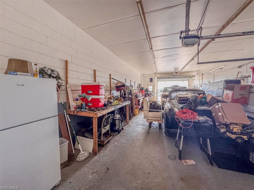 Right side of Main Building Garage featuring a garage door opener and workshop
