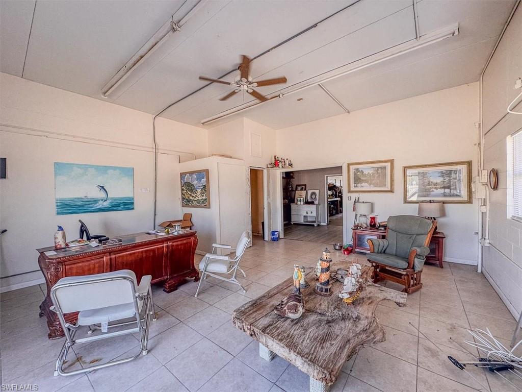 Living room with light tile patterned flooring and ceiling fan