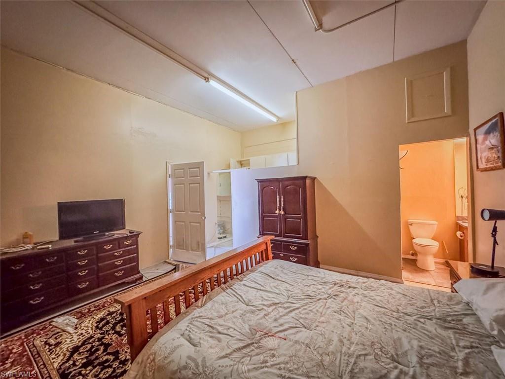 Bedroom featuring tile patterned floors and connected bathroom