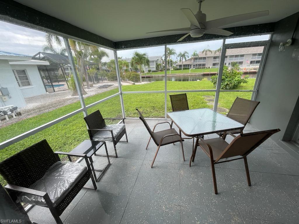 Sunroom featuring ceiling fan and a water view