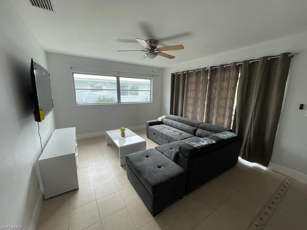 Tiled living room featuring ceiling fan