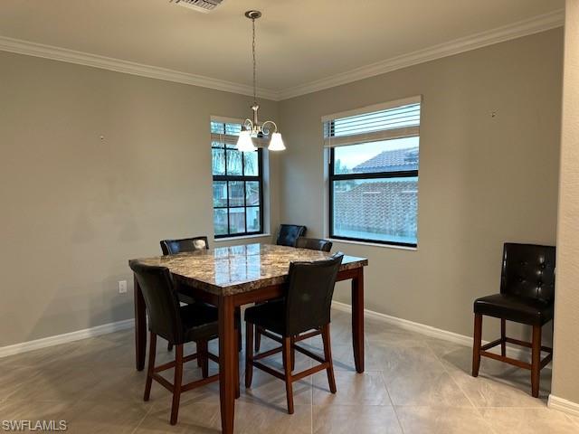 Dining area with ornamental molding, light tile patterned floors, and a notable chandelier