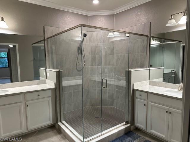 Master Bathroom featuring dual sinks and an enclosed shower, crown molding, vanity, and tile patterned floors