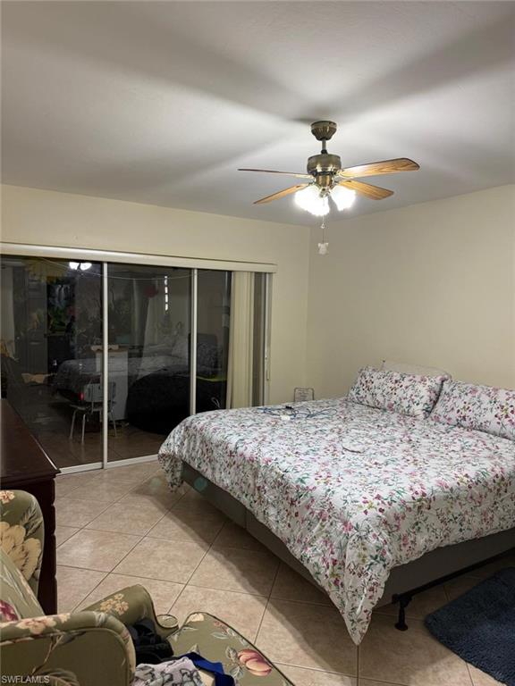 Tiled bedroom featuring access to exterior and ceiling fan