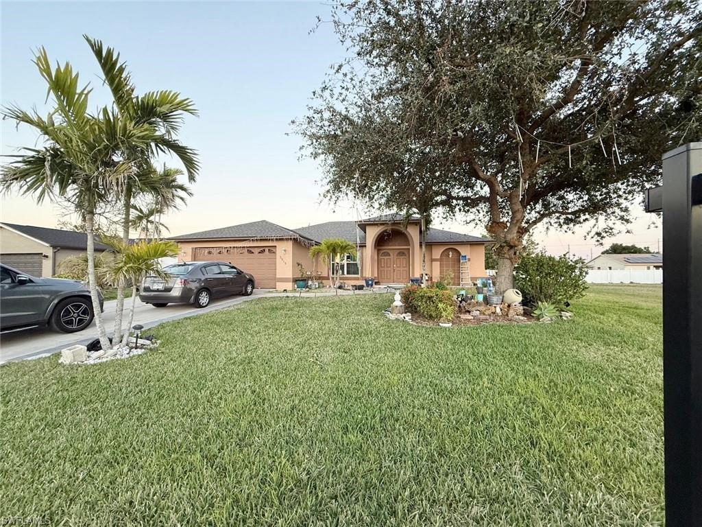 Ranch-style home with a garage and a lawn