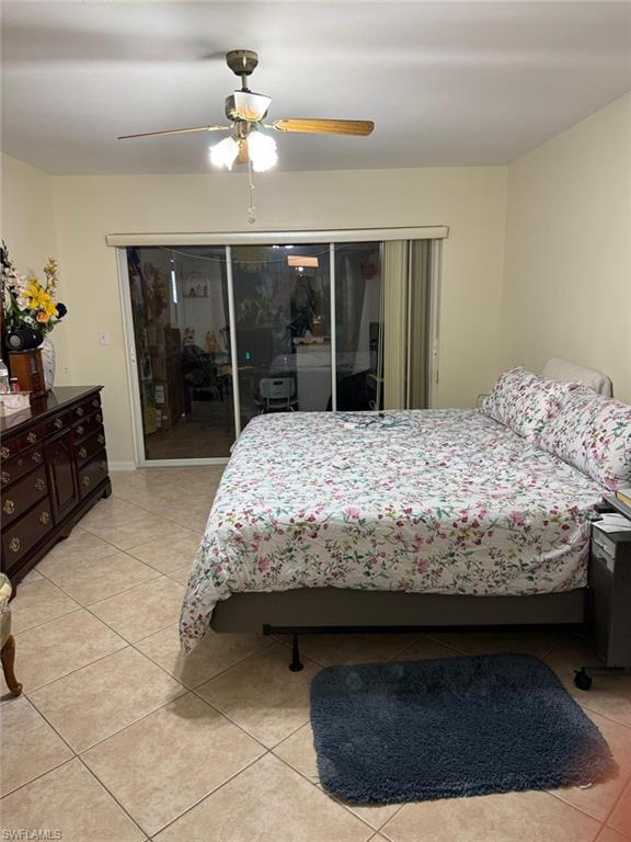 Tiled bedroom featuring access to outside and ceiling fan