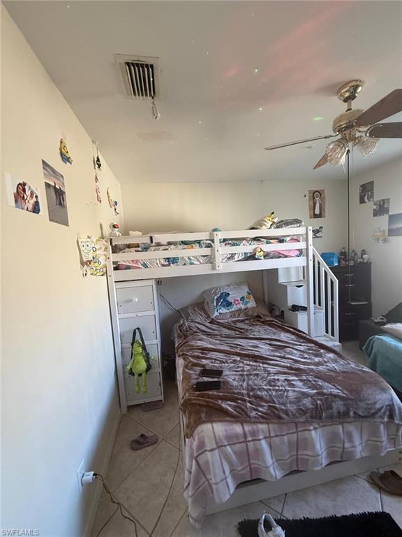 Bedroom featuring light tile patterned floors and ceiling fan