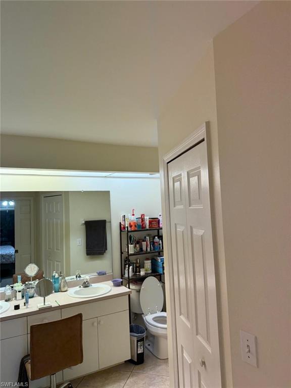 Bathroom with vanity, toilet, and tile patterned flooring