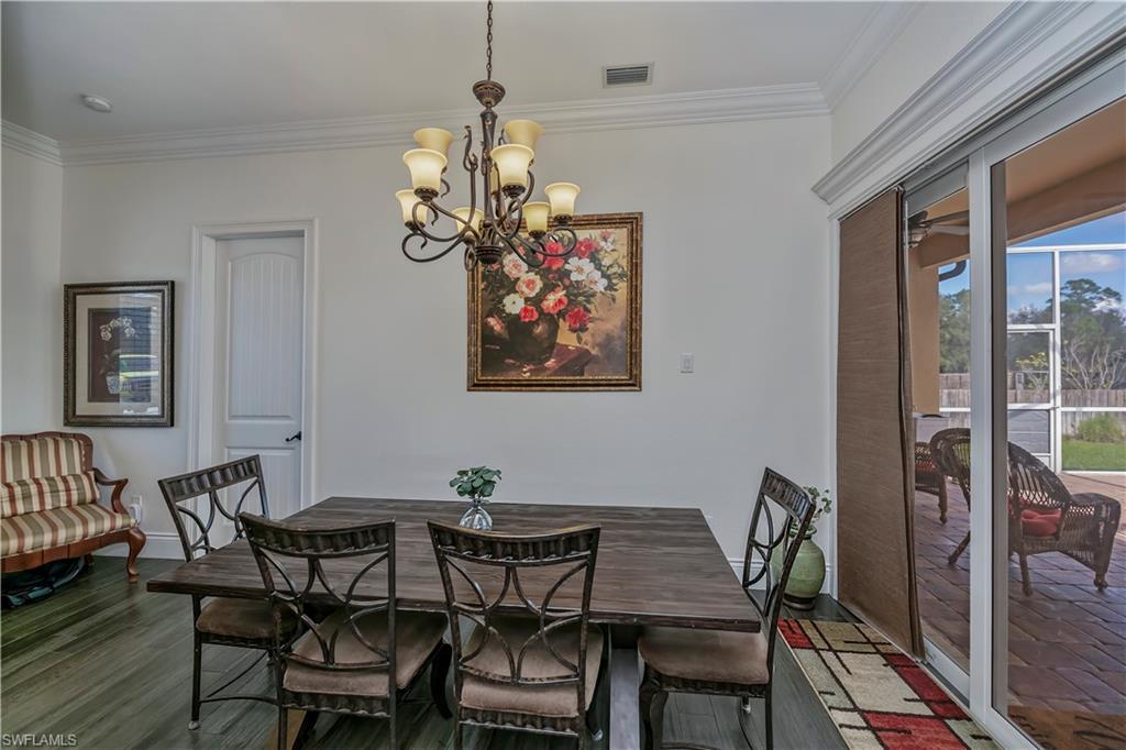 Dining area with notable chandelier, wood-type flooring, and ornamental molding