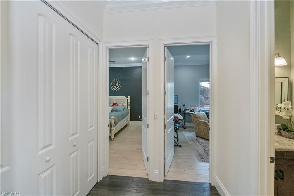 Corridor featuring ornamental molding and dark hardwood / wood-style flooring