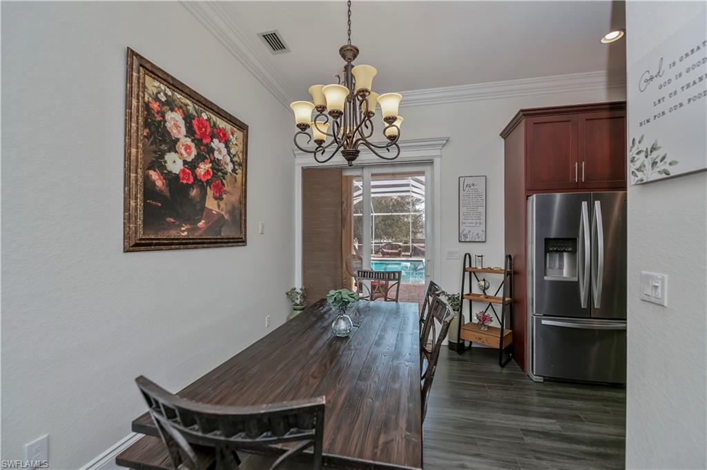 Formal Dining area featuring ornamental molding, dark hardwood / wood-style flooring, and an inviting chandelier