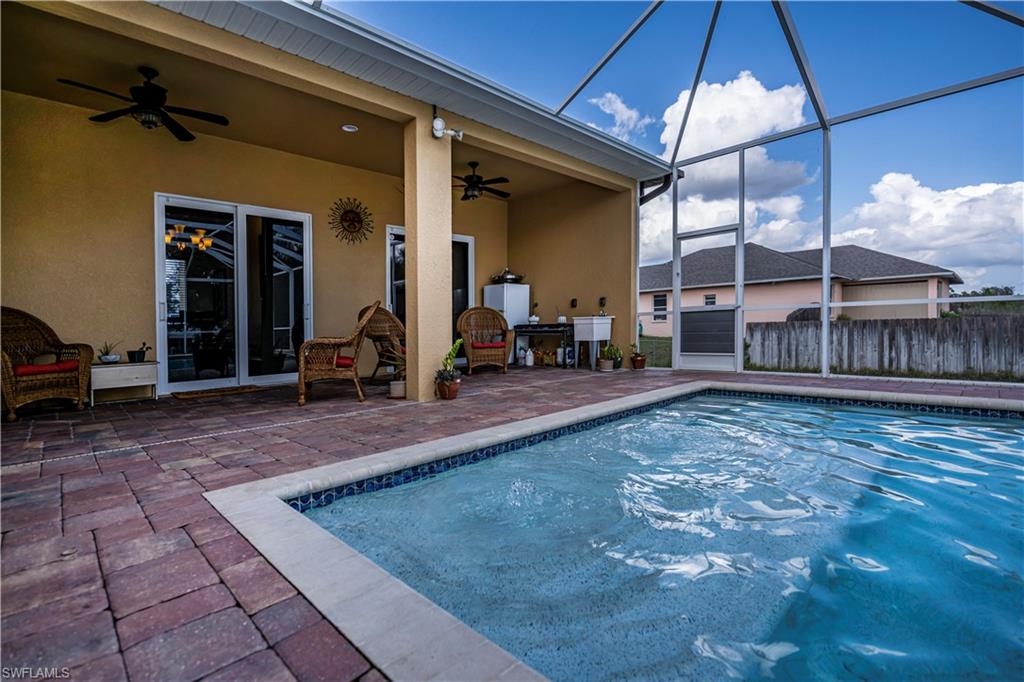 View of pool featuring ceiling fan, a lanai, and a patio