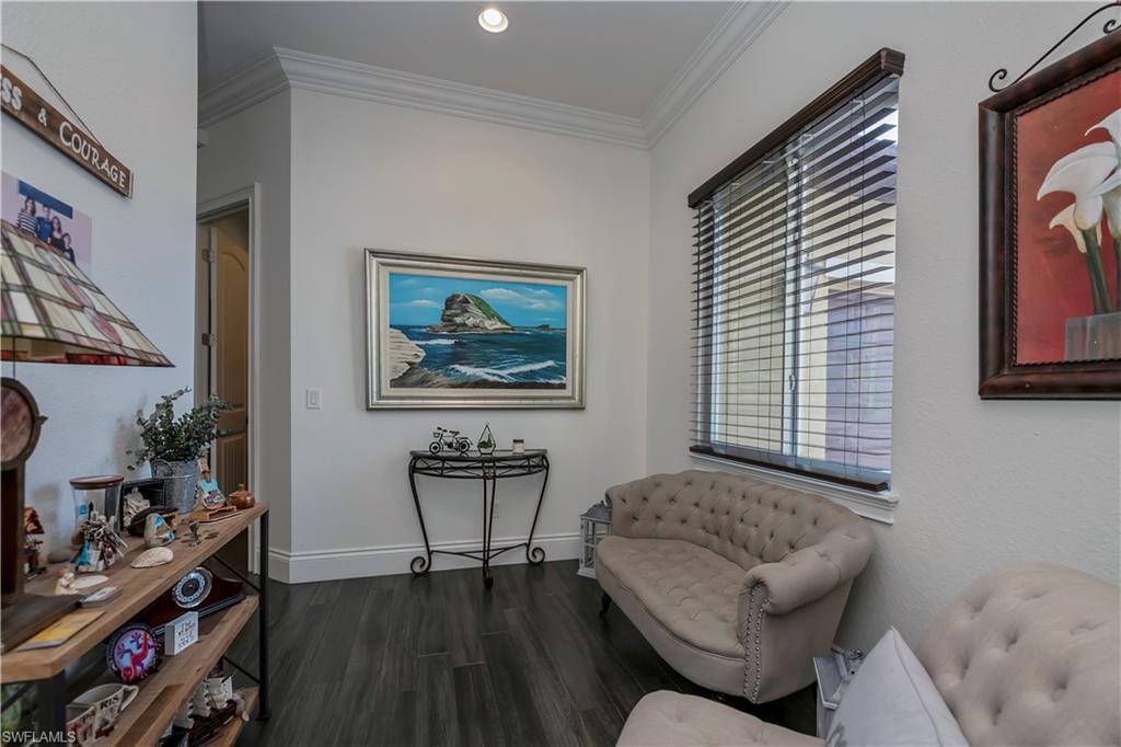 Sitting room featuring crown molding and dark hardwood / wood-style flooring