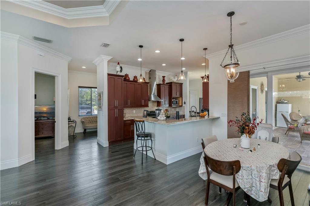 Dining area with crown molding and dark wood-type flooring