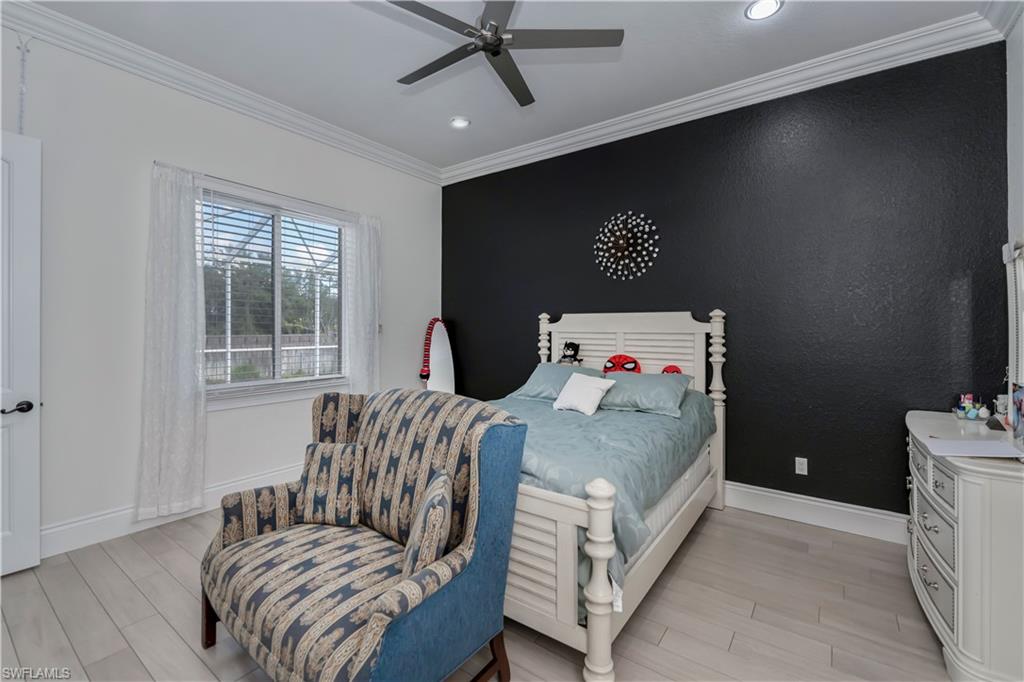 Bedroom with crown molding, light hardwood / wood-style flooring, and ceiling fan