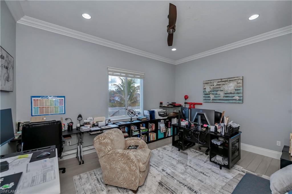 Office with crown molding and light hardwood / wood-style flooring