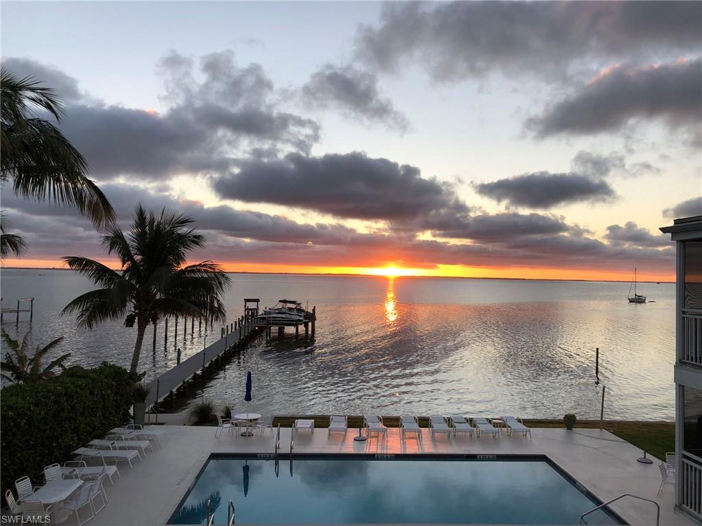 Community pool with a water view and a dock