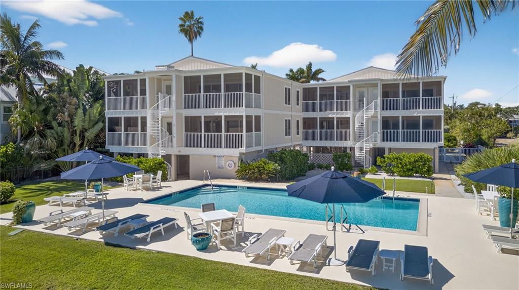 Community pool with stairway, a lawn, and a patio area