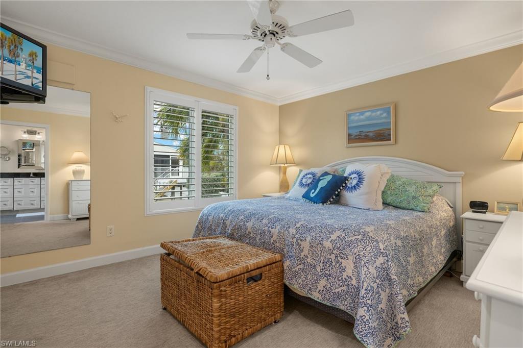 Bedroom with crown molding, carpet floors, and ceiling fan
