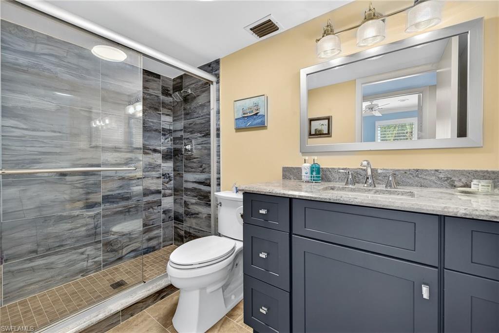 Full bathroom with a shower stall, vanity, and light tile patterned floors