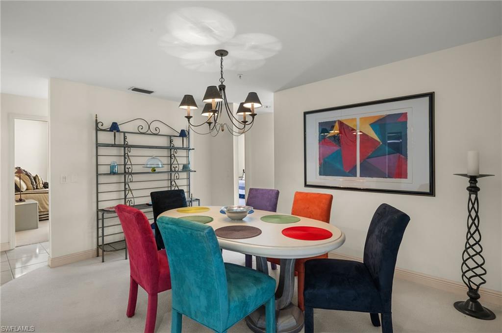 Dining space featuring an inviting chandelier and light colored carpet