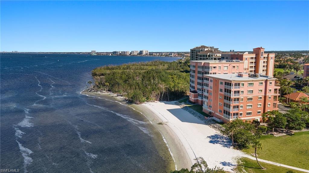 Birds eye view of property featuring a water view and a view of the beach