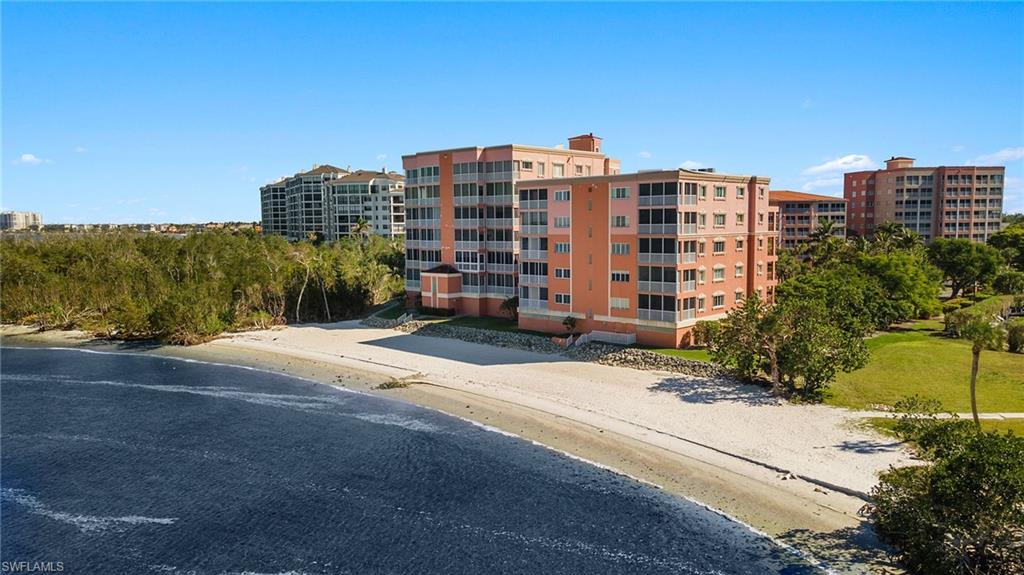 View of building exterior featuring a water view and a beach view