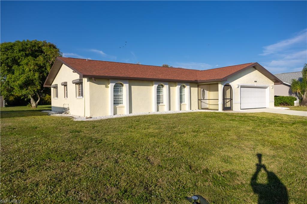 Ranch-style home featuring a garage and a front yard