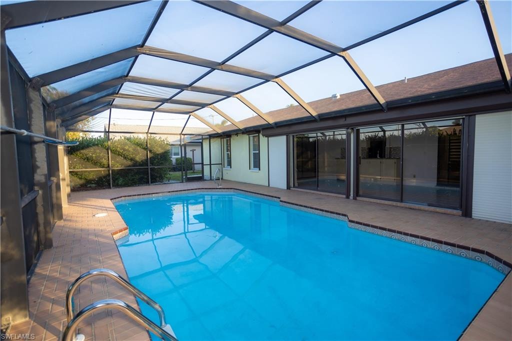 View of swimming pool with a patio and a lanai