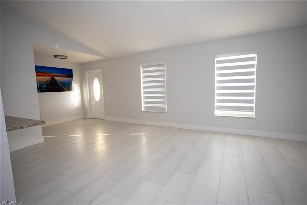 Spare room featuring vaulted ceiling