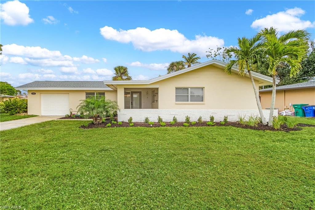 Ranch-style home with a garage and a front lawn
