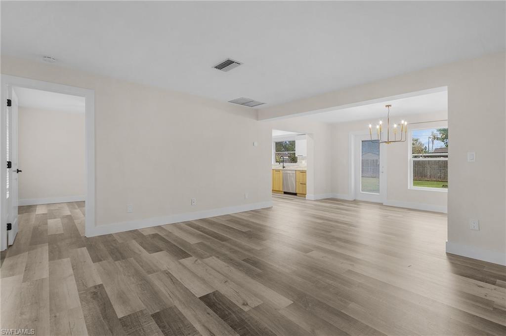 Completely remodeled living room with light hardwood / wood-style flooring and a chandelier
