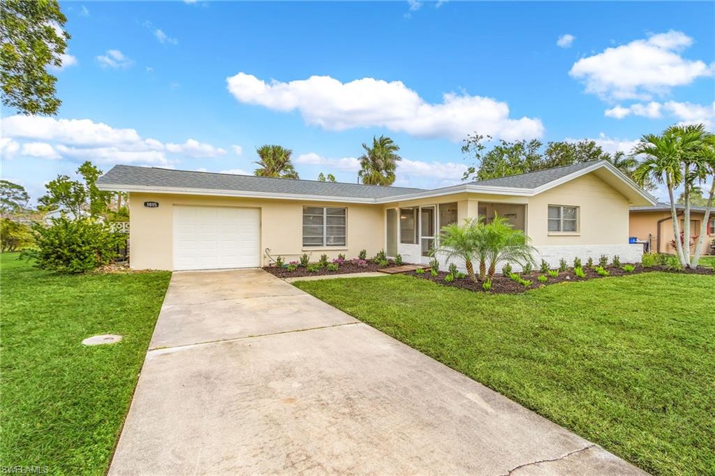 Ranch-style home with a garage and a front lawn
